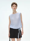 Woman wearing a light blue sleeveless top and black skirt with a white background